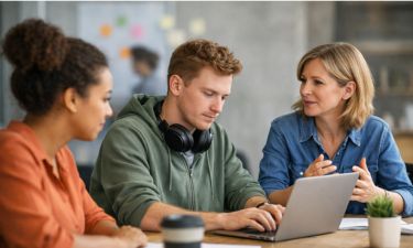 Manager having discussion with two team members, including one who is neurodivergent with ear defenders around his neck