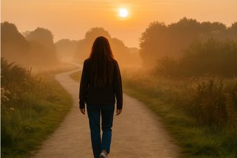 Woman walking along an authentic path towards the sunset