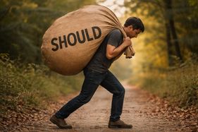 A man carrying a sack with Should written on it, indicating the importance of knowing when to use the word should