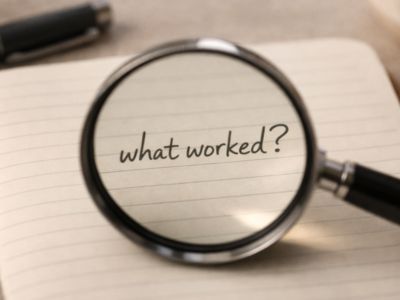 A magnifying glass over the words 'what worked?' on a page, indicating further exploration
